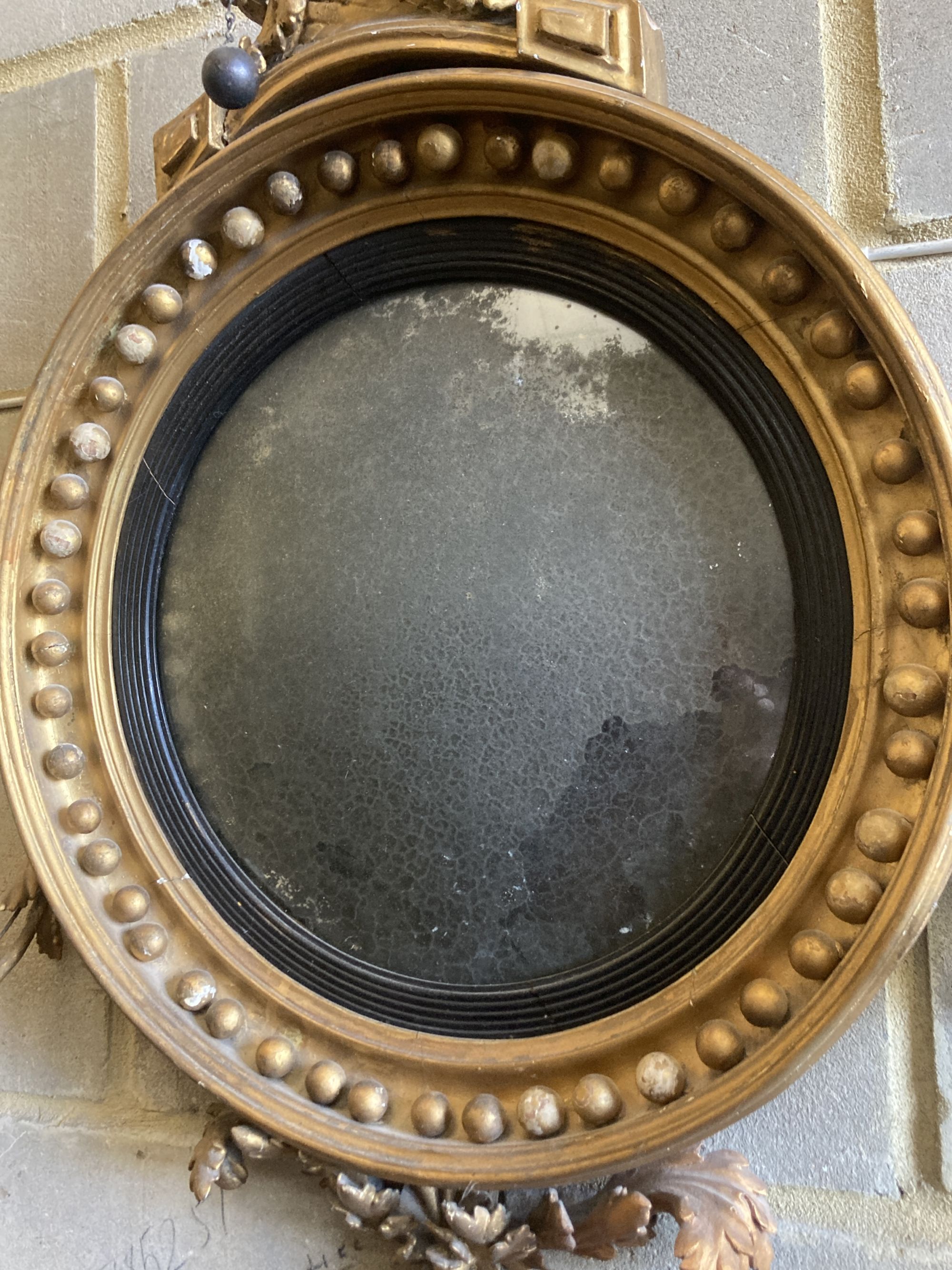 A Regency carved giltwood and gesso convex girandole wall mirror, width 65cm, height 90cm